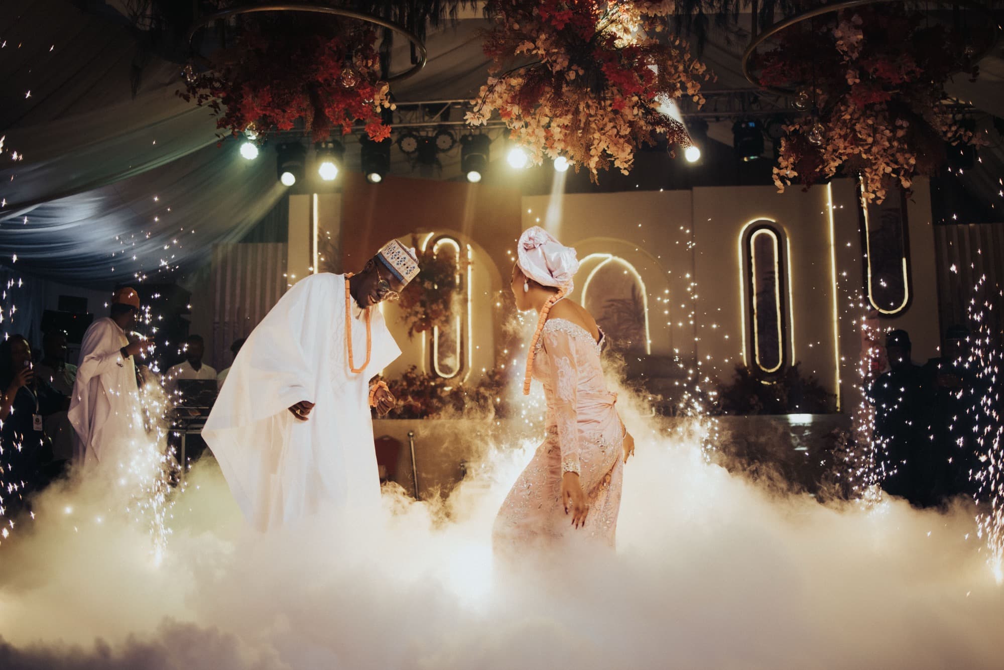 Ore and Esi on the dance floor amid sparklers and dry ice at their traditional reception.