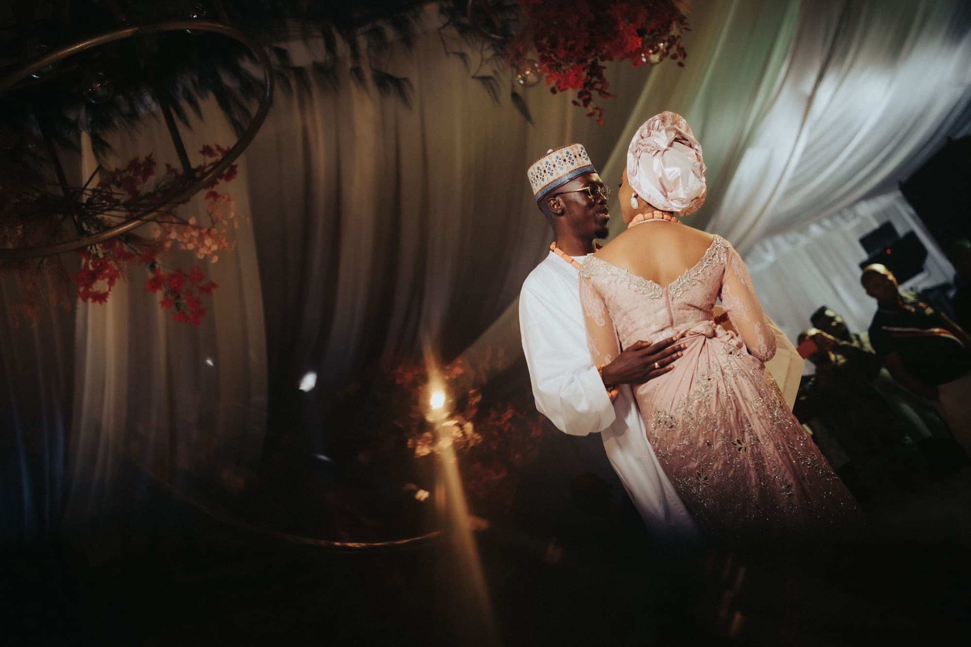 Ore, in blush lace, and Esi share a quiet moment at the traditional celebration.